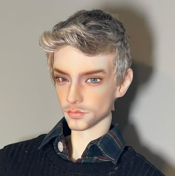 A tan male doll with blond hair